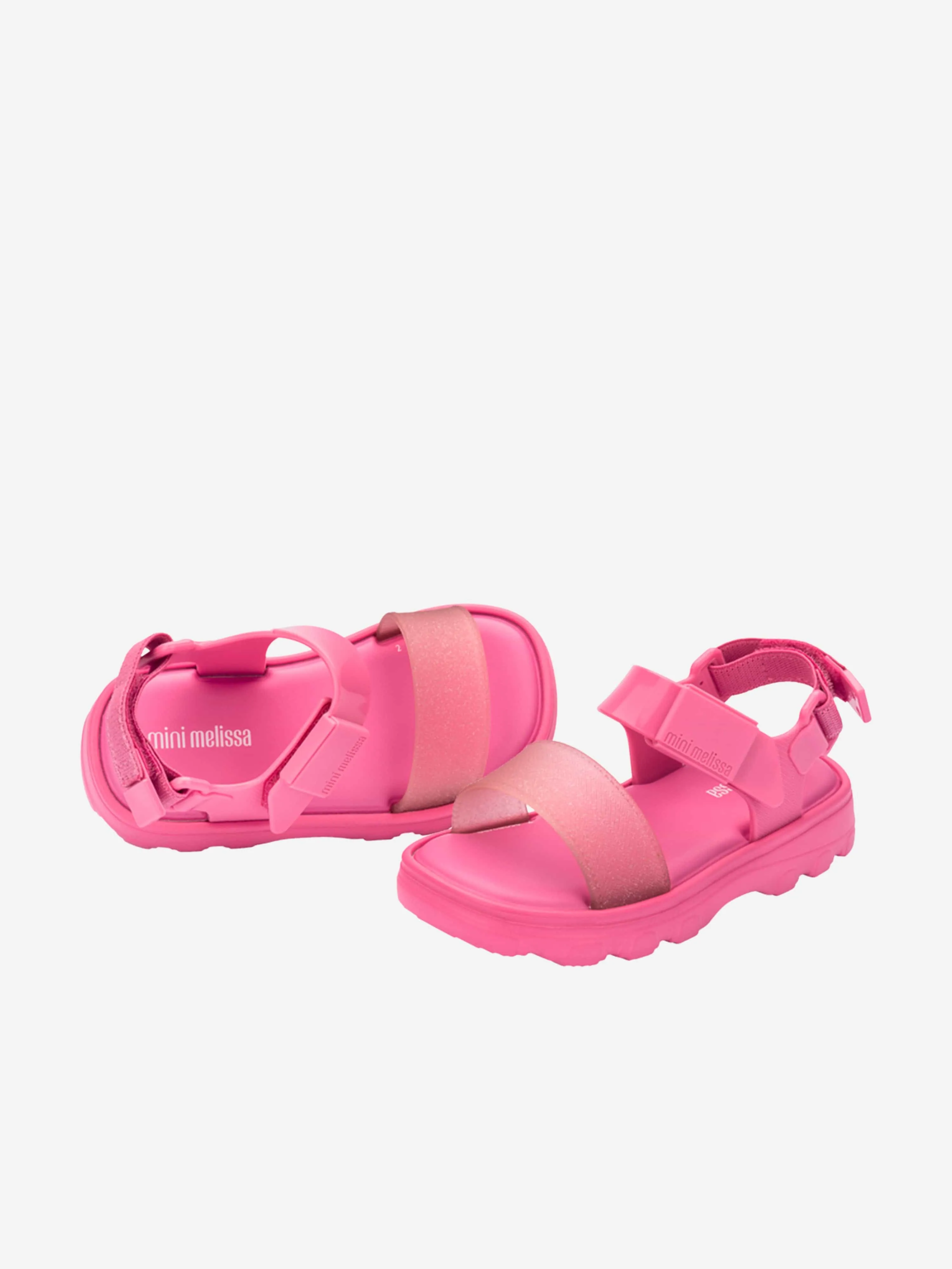 Mädchen stoßen Sandalen in Rosa ab